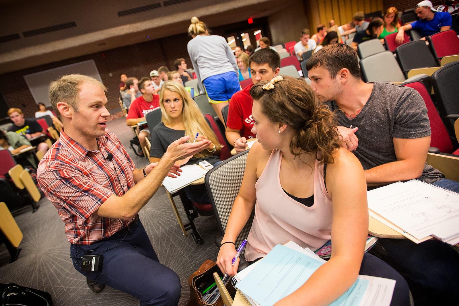 Professor discussing material with students in lecture hall