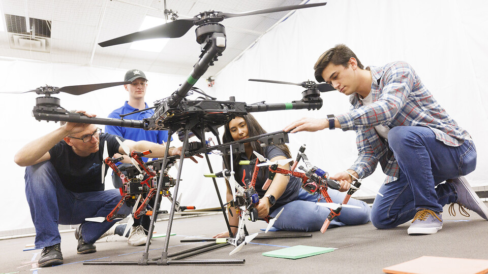 students looking at drone helicopter