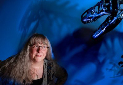 Kate Lyons posed under dinosaur fossil