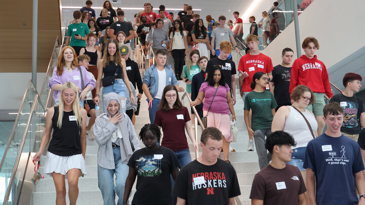 Dozens of Nebraska Engineering students walk down a staircase in Kiewit Hall.