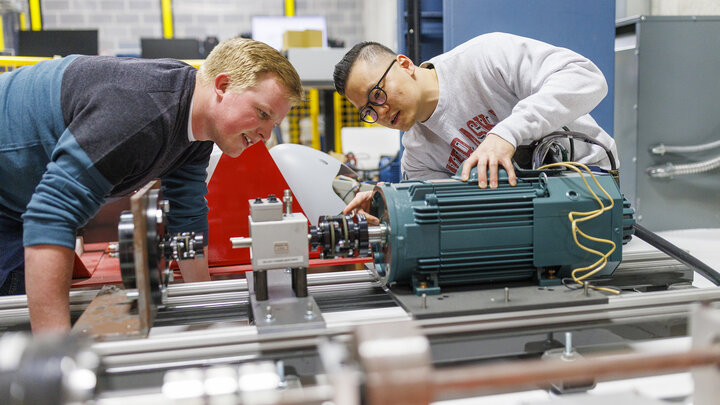 Jun Wang, on right, explains power trains in an electrical engineering lab.