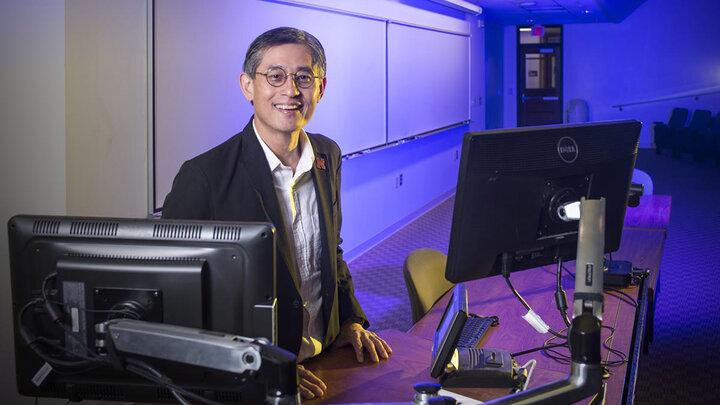 Leen Kiat-Soh standing by a computer