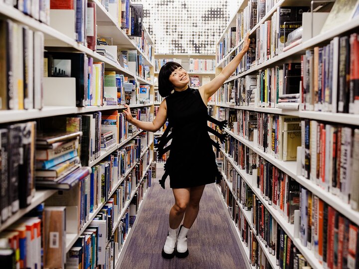 Caroline hu walking down a book aisle