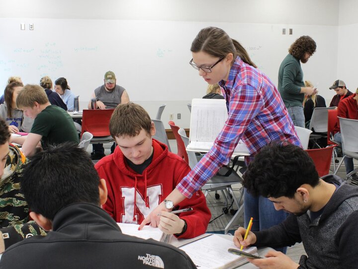 someone observing student's work and giving them assistance