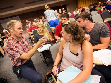 teacher in classroom talking to students