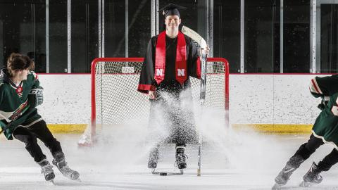 Alex Cathcart came to Nebraska to pursue a hockey career, but he scored with a mathematics degree from the University of Nebraska–Lincoln. He is assisted in the photo by John Rupert, a sophomore from Minnesota.