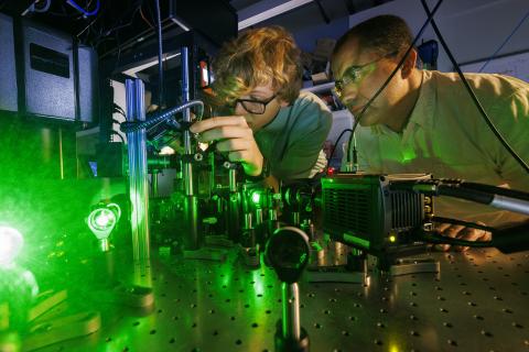 Ben Hammons, a freshman in electrical engineering, and Abdelghani Laraoui, assistant professor in mechanical and materials engineering, work on laser equipment.