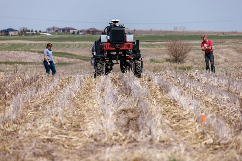 Graduate research assistant Taylor Cross (left) and graduate student Ian Tempelmeyer walk behind the Flex-Ro autonomous planting robot as it starts a row at Rogers Memorial Farm, east of Lincoln. Santosh Pitla, associate professor of advanced machinery systems at Nebraska, has managed the project since the robot’s inception in 2015.