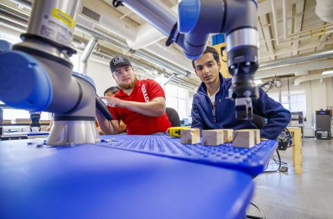 Jacob Hansen, with ALA Engineering and a Nebraska alumnus, and Kunjan Theo Joseph, with the UNL MAARS Lab, work at making their robotic arm program stack blocks at Nebraska Innovation Studio. The programming would simulate a larger robotic arm stacking pallets. 